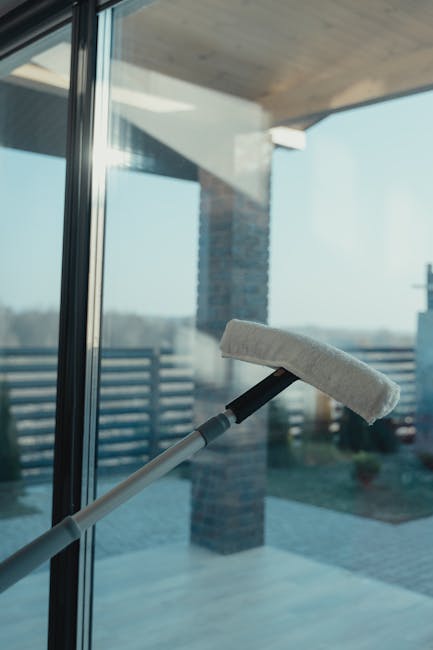 Window washing service near your in Lake Martin, Alabama - A modern cleaning tool used to clean a large glass window with a clear outdoor view.